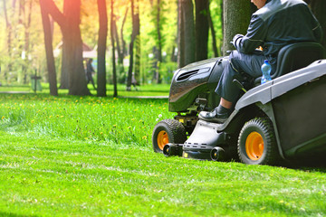Professional lawn mower wirh worker cut the grass