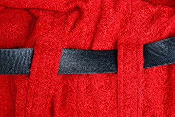 red woolen cloth background on clothes and black leather belt