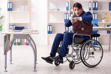 Young male employee in wheelchair working in the office 