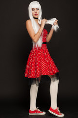 Portrait of awoman in a white wig, red dress and sneakers. Studio photo session