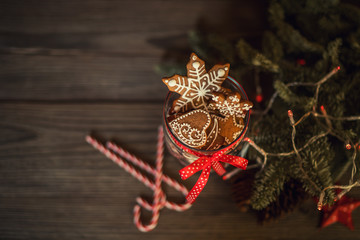 Christmas gift with homemade gingerbread cookies, nuts and chocolates. Glass jar, fir branches, Christmas spices and decor. Winter holidays, New Year or Christmas concept. Top view with copy space.