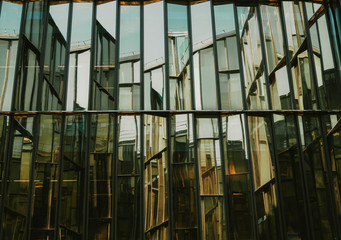 Glass window of a building with black aluminum frames, blue tone as background.