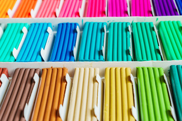 Rainbow colors of modeling clay. Multicolored plasticine bars ina box, background texture
