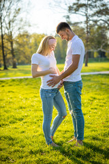 Happy couple expecting baby, pregnant woman with husband, young family and new life concept