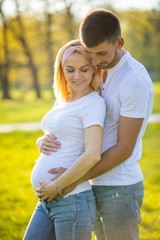 Happy couple expecting baby, pregnant woman with husband, young family and new life concept