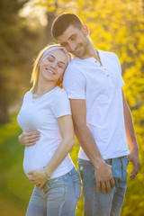 Happy couple expecting baby, pregnant woman with husband, young family and new life concept