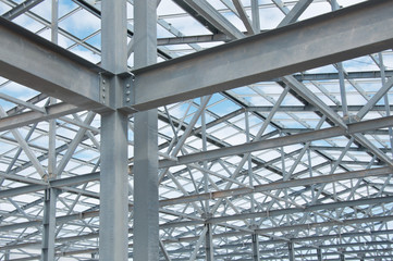 Metal frame of the new building against the blue sky with clouds