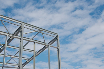 Metal frame of the new building against the blue sky with clouds