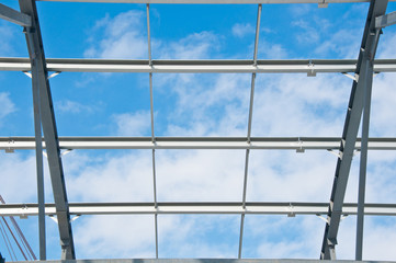 Metal frame of the new building against the blue sky with clouds