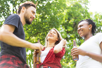 friends talking and toasting beers outdoors. Party people drinks toast celebration.