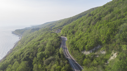 Aerial view over mountain road going through forest landscape, Winding road from high mountain pass.