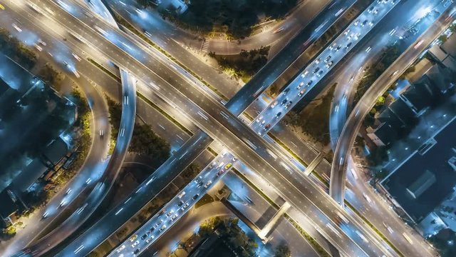Aerial top view rotate trun right intersection road traffic in city at night, 4K, time lapse, bangkok , thailand.