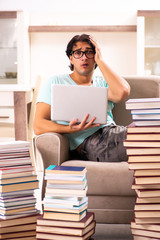 Male student with many books at home 