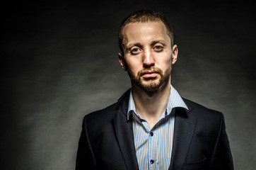 Fototapeta premium fine portrait of a white man with a beard in a business suit on a black background