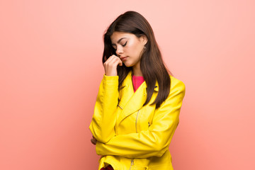 Teenager girl over pink wall having doubts