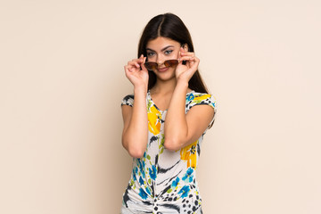 Teenager girl with floral dress with glasses and surprised