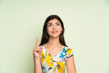 Teenager girl with floral dress pointing with the index finger a great idea