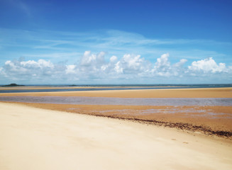 Tropical beach in Bahia, Brazil. Beautiful clouds on empty beach with different color tones of sand.