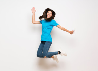 Fototapeta na wymiar Teenager girl jumping over isolated white wall