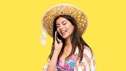 Teenager girl on summer vacation keeping a conversation with the mobile phone over isolated yellow background