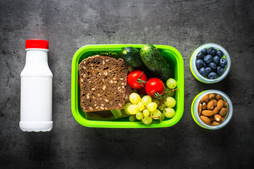 Lunch box with sandwich, vegetables, banana, yogurt, nuts and ber
