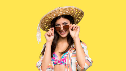 Teenager girl on summer vacation with glasses and surprised over isolated yellow background