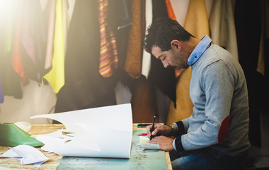 Shoe designer working with paper models for leather cutting.