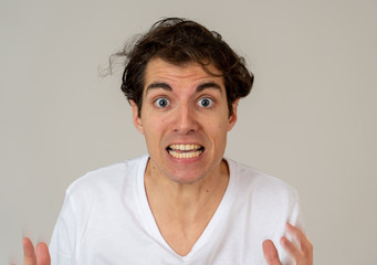 Portrait of a young man looking scared and shocked. Human expressions and emotions
