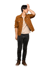 A full-length shot of a Asian man with brown jacket has realized something and intending the...
