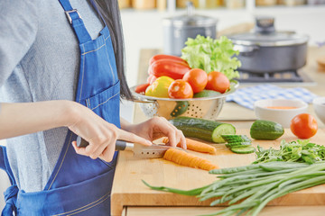 A young woman prepares food in the kitchen. Healthy food - vege
