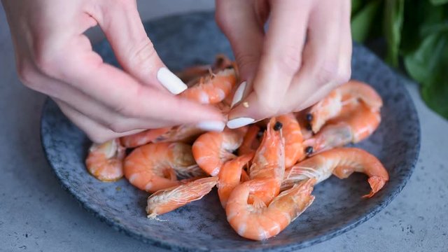 Woman cleaning shrimps with hands. Closeup view