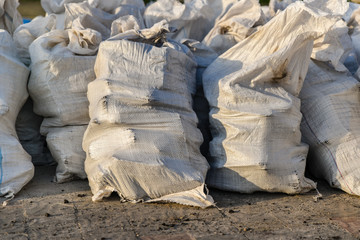 Group of filled plastic woven sacks, packing of goods for transportation and storage in a...