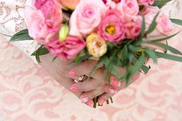 Wedding bouquet of pink roses and eustoma in the hands of the bride
