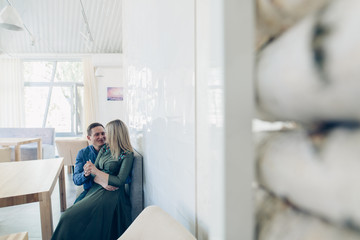 Couple in love looking at each other and smiling.. Guy hugging a girl indoor.Romantic relationship in cafe. portrait of an emotional love couple indoor. romantic date in restaurant