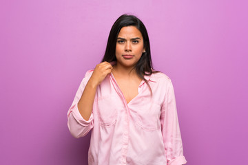 Fototapeta premium Young Colombian girl over purple wall with tired and sick expression