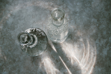 Vodka in two decanters on a marble surface top view light from the window selective focus