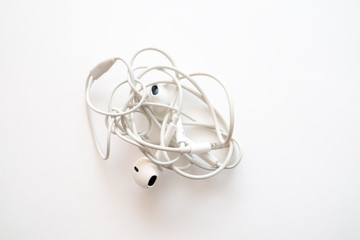 headphones on a white background the wires of the headphones are tangled