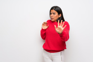 Young Colombian girl with red sweater nervous stretching hands to the front