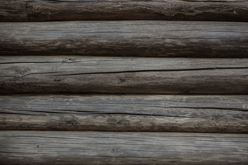 Fototapeta premium Fragment of old weathered log wall, natural grey horizontal background texture detail close up