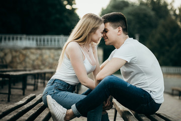 A young couple in love kissing on the bench in the park