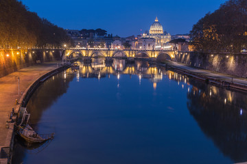 Fototapeta na wymiar Tiber and St Peters Basilica with Aurelius Bridge or Ponte Sisto bridge at blue hour with a sunken boat on the shore with lighting. Stone bridge over river Tiber in the historic center of Rome