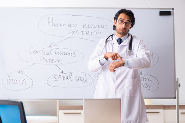 Young male doctor neurologist in front of whiteboard 