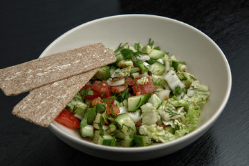 Beige plate with salad on dark background. Top view