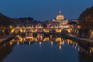 Fototapeta na wymiar Tiber and St Peters Basilica with Aurelius Bridge or Ponte Sisto Bridge at the blue hour with lighting and reflections. Stone bridge at night over river Tiber in the historic center of Rome