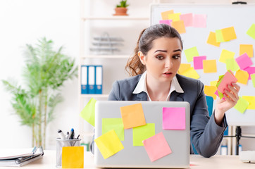 Young female employee in conflicting priorities concept 