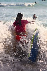 Fototapeta premium SILHOUETTE OF GIRL SURROUNDED BY WAVES IN THE SEA IN VACATION