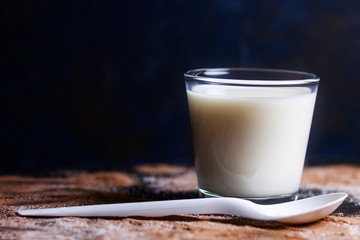 GLASS OF MILK WITH COOKIE AND SPOON FOR BREAKFAST ON DARK BACKGROUND 3