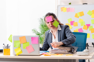 Young female employee in conflicting priorities concept 