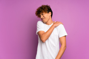 Young african american man over isolated purple wall suffering from pain in shoulder for having made an effort