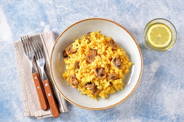 Traditional Italian risotto with  mushrooms, saffron, parmesan cheese, vegetable broth and white wine. Top view. Copy space. 